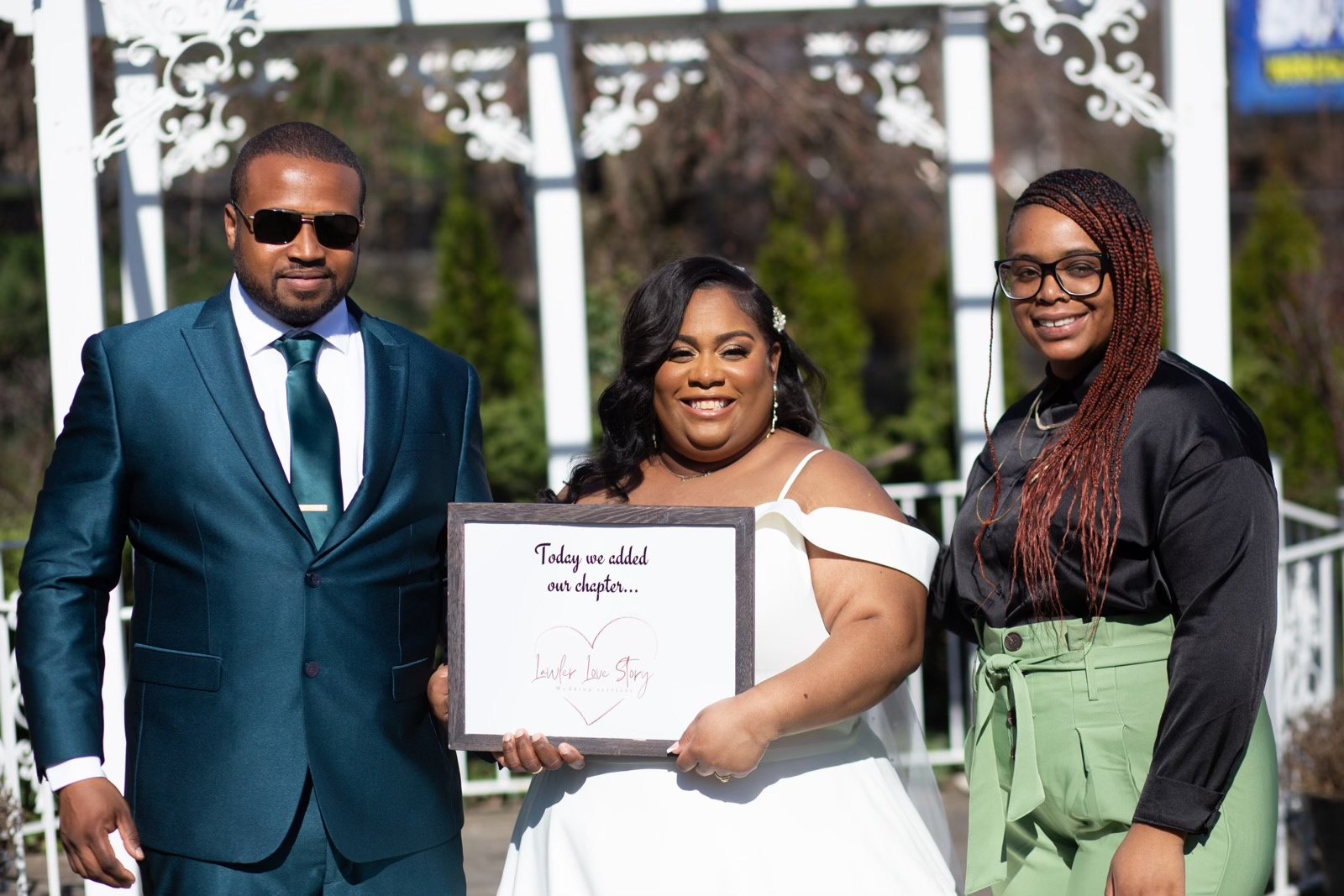 a bride and groom pose for a picture with wedding officiant